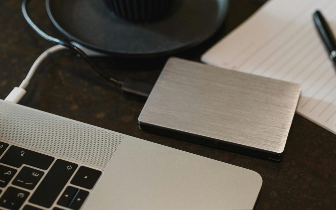 Free Closeup of an external hard drive connected to a laptop with a USB cable on a desk. Stock Photo